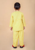 Boy wearing yellow zig zag pajama set, back standing pose