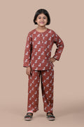 Child wearing a brown pajama set with animal pattern on a beige background