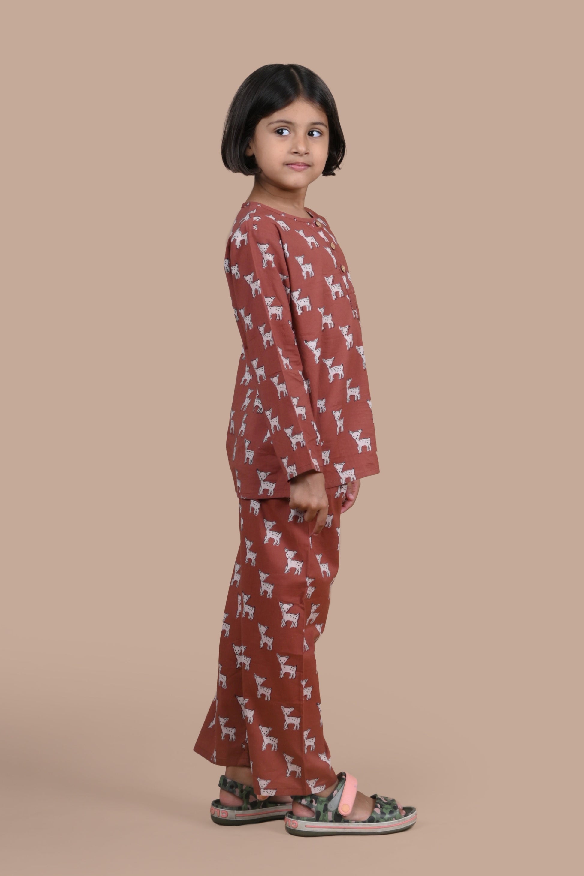 Child wearing a brown deer patterned outfit 