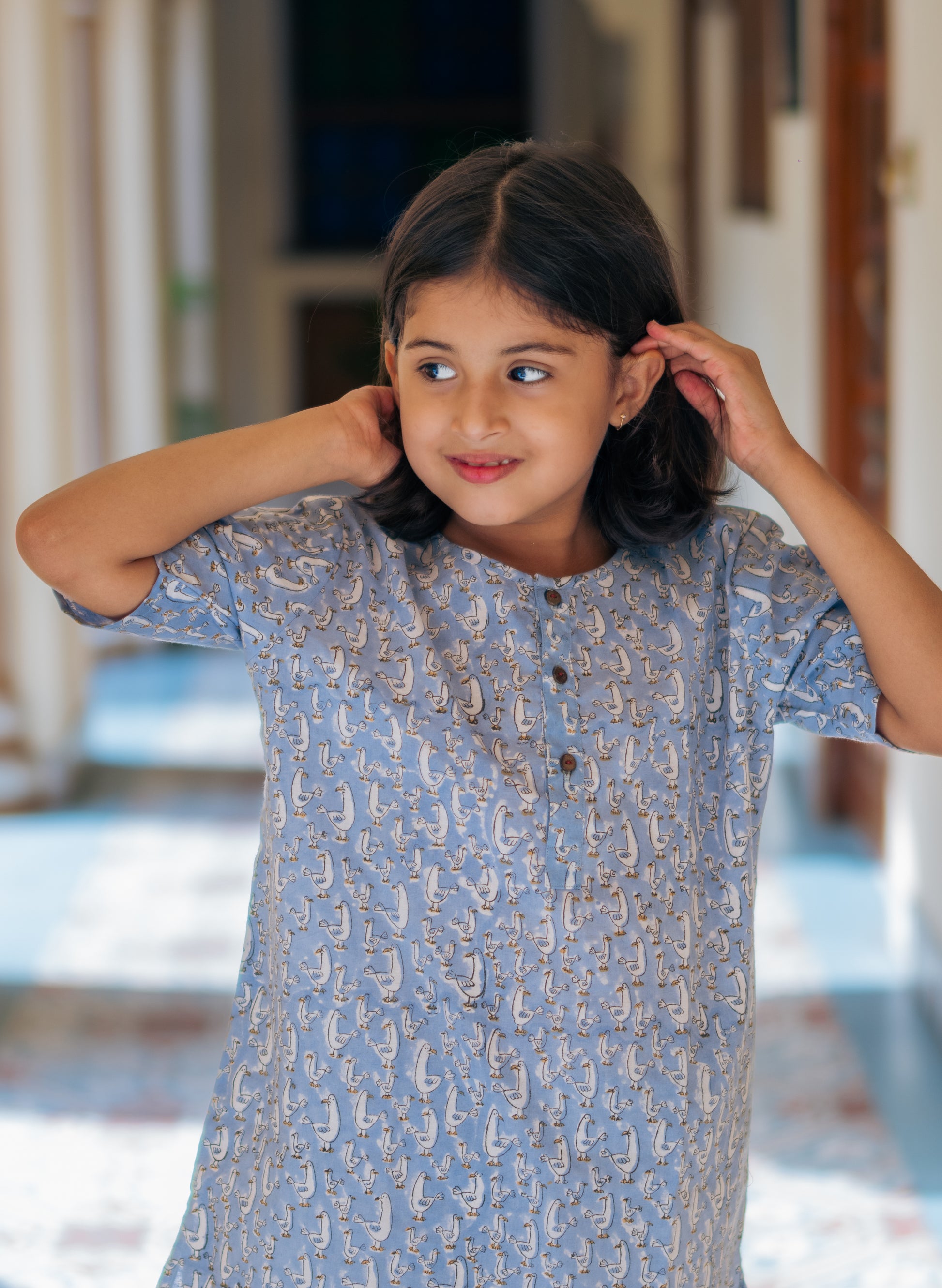 Young girl wearing a duck nightsuit indoors